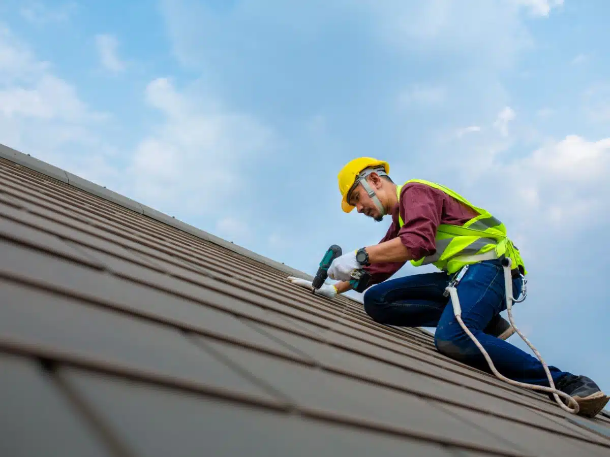 Worker fixing a roof tiles