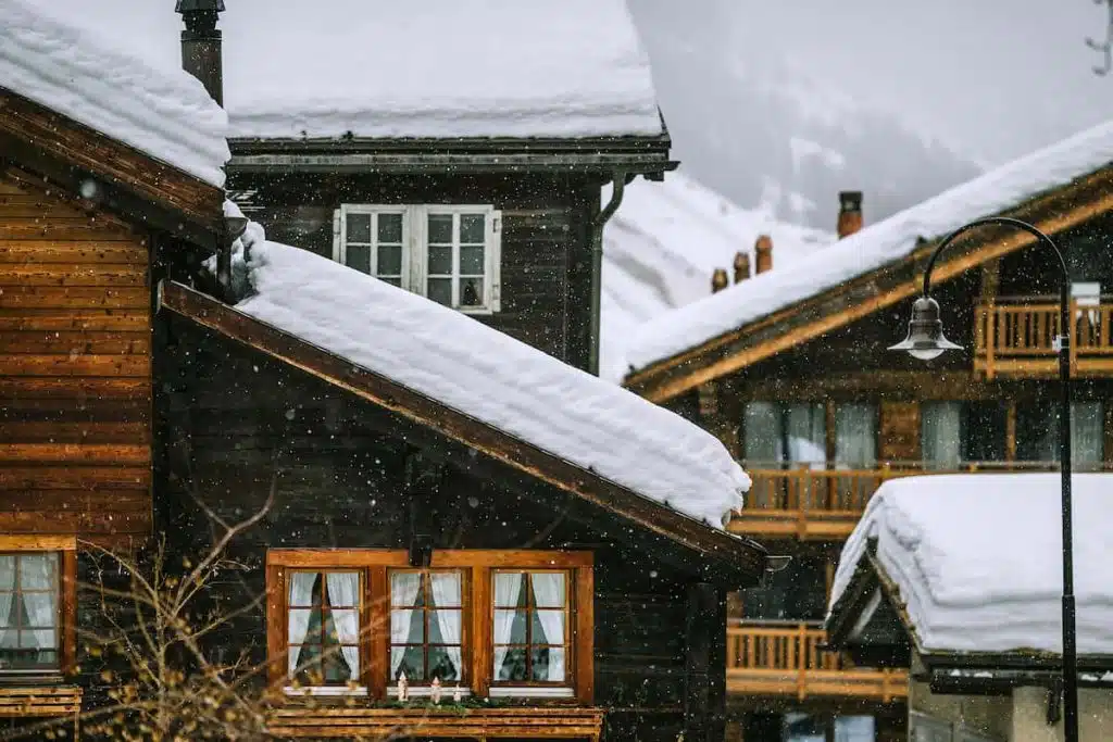Wooden-houses-covered-with-snow-in-mountainous-valley-in-winter